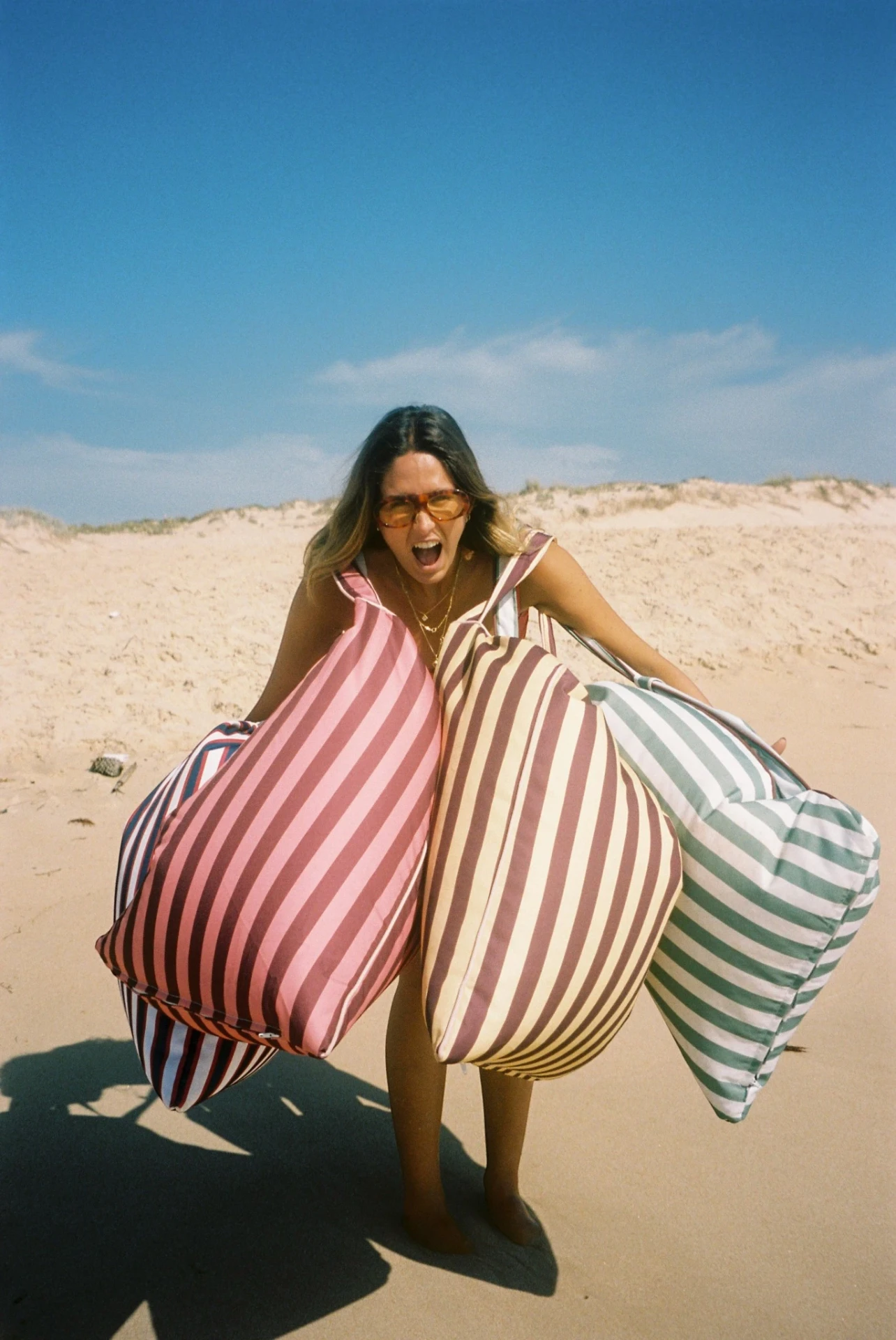 Model on the beach carrying four LIELOW bags